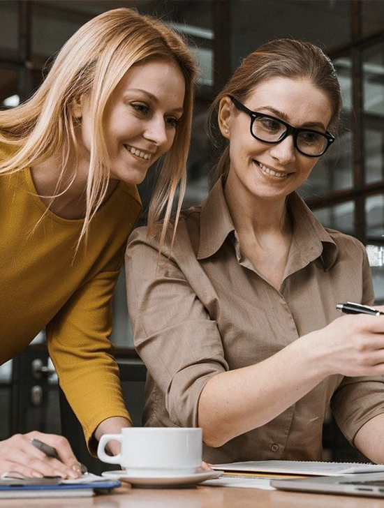 2 women looking at the paper